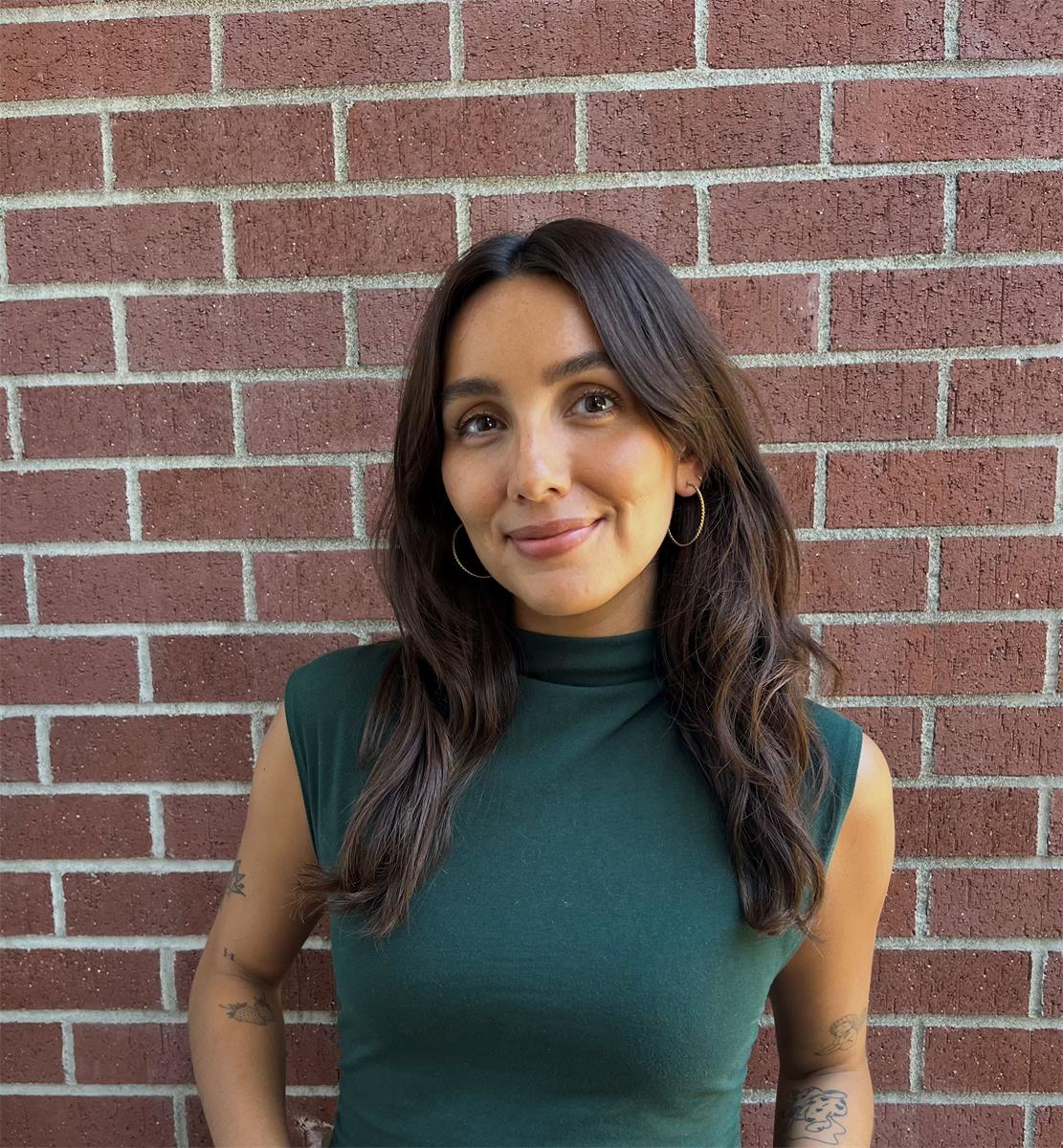 portrait of Celeste against a brick wall